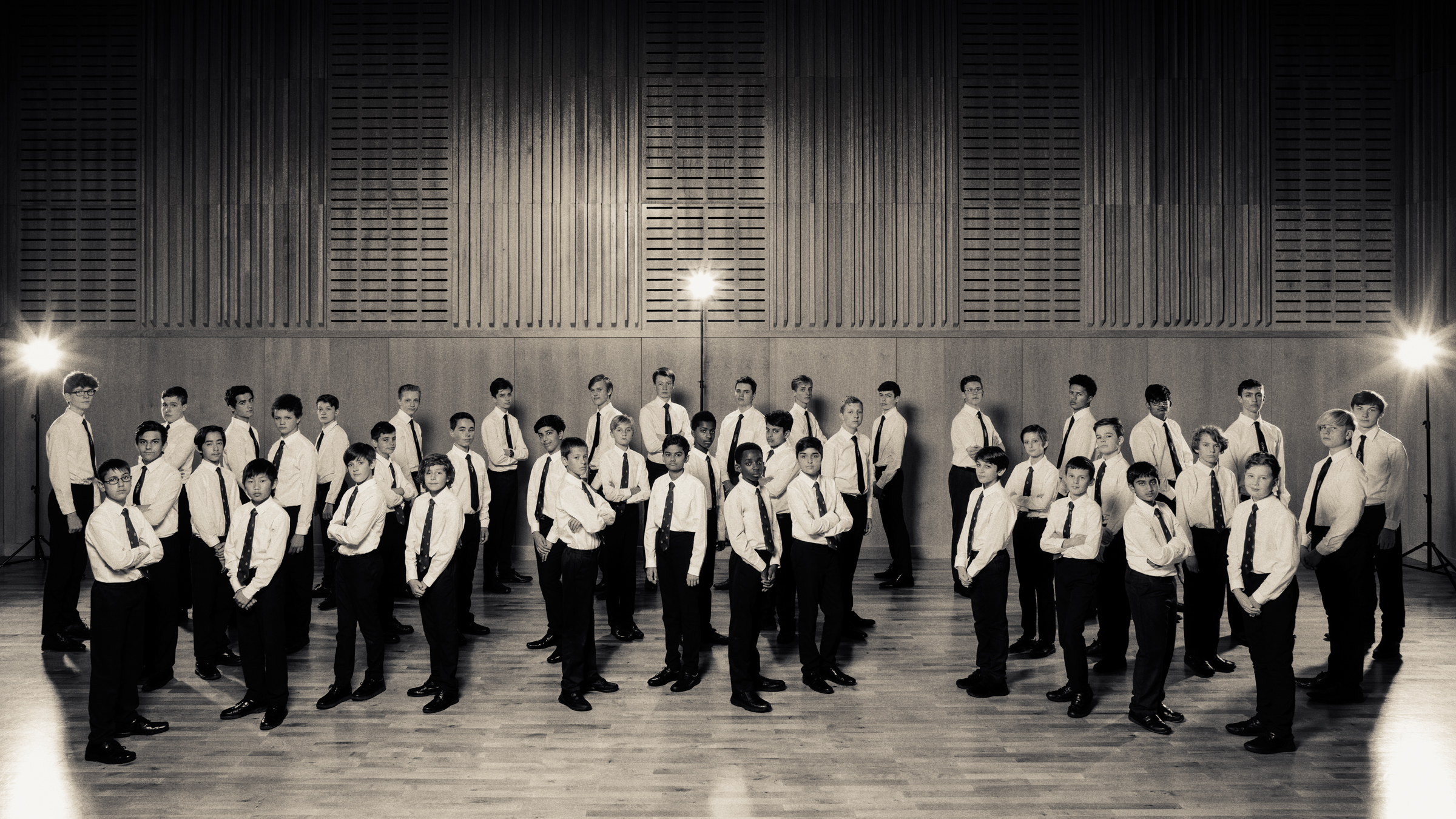 ein Knabenchor: Jungen,stehend, in schwarzen Hosen, weißen Hemden mit schwarzen Krawatten